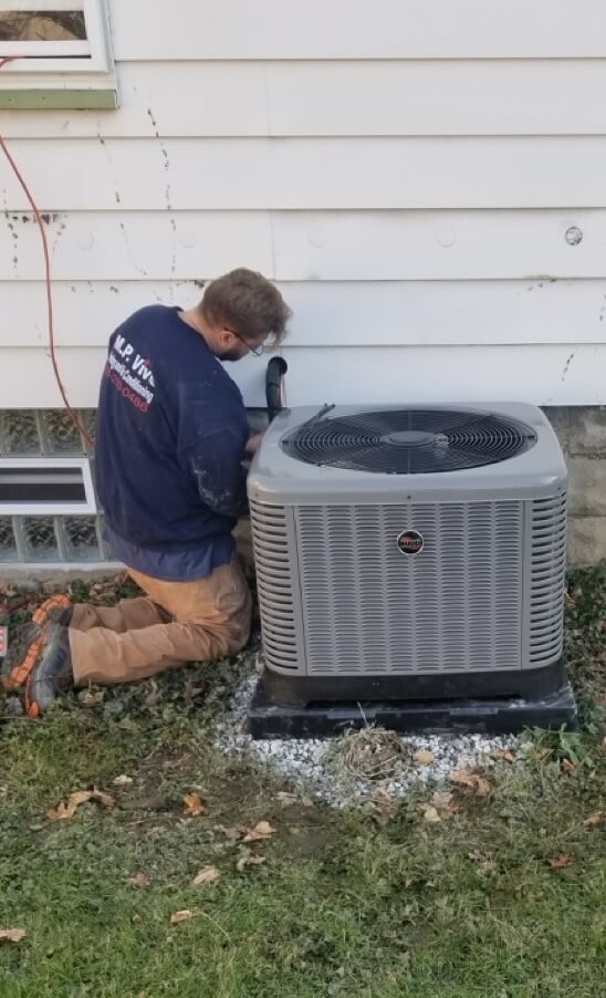 MP Vivo Employee kneeling next to air conditioning system