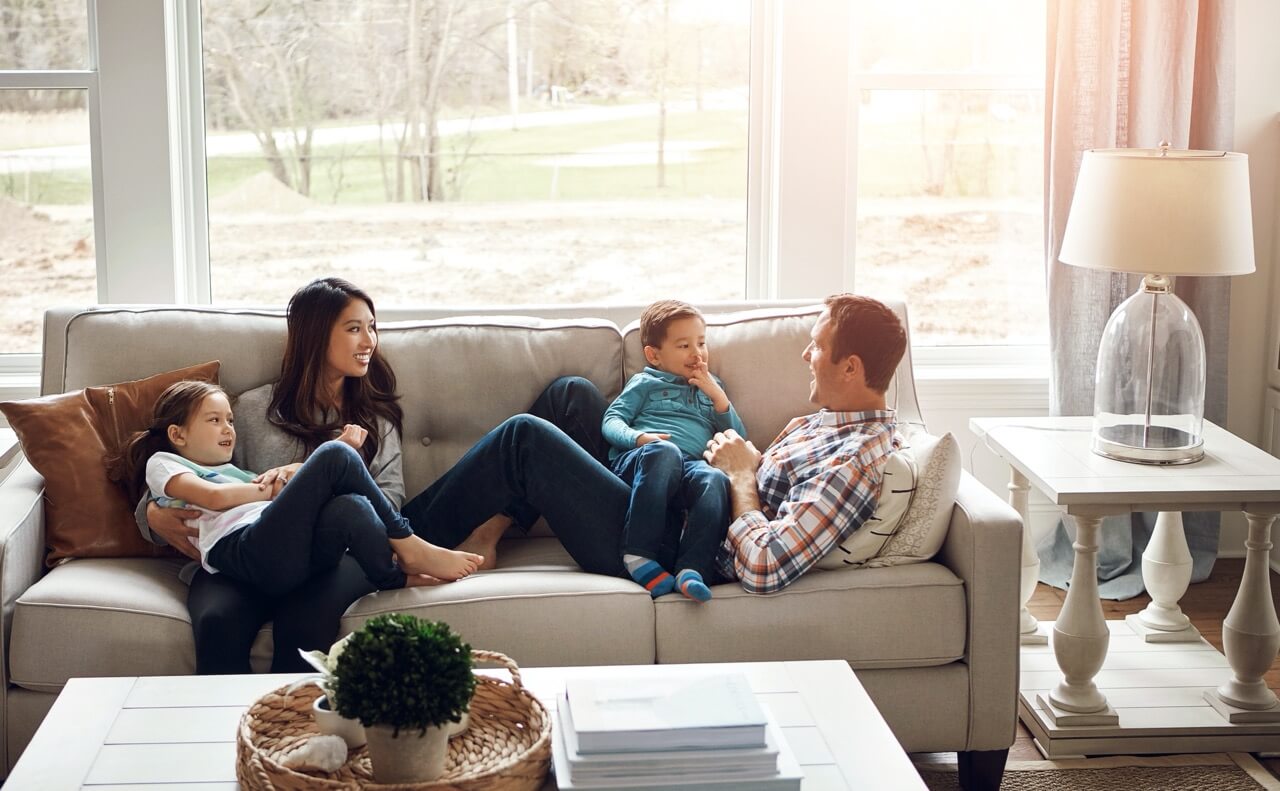 Family sitting on couch next to window